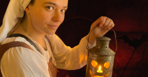 une comédienne tient une lampe à huile